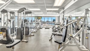 A gym with various exercise machines, large windows, and a concrete floor. - Spectacular Ocean/Beach Front Condo, Awesome view of Gulf- w/ Free Beach Service (Destin)