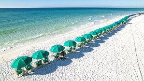 A beach with rows of green umbrellas and chairs along the shoreline. - Spectacular Ocean/Beach Front Condo, Awesome view of Gulf- w/ Free Beach Service (Destin)