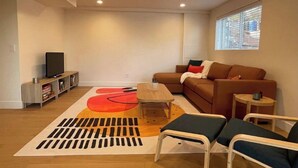 Een moderne woonkamer met een modulaire bank, een salontafel en een tv op een meubel.