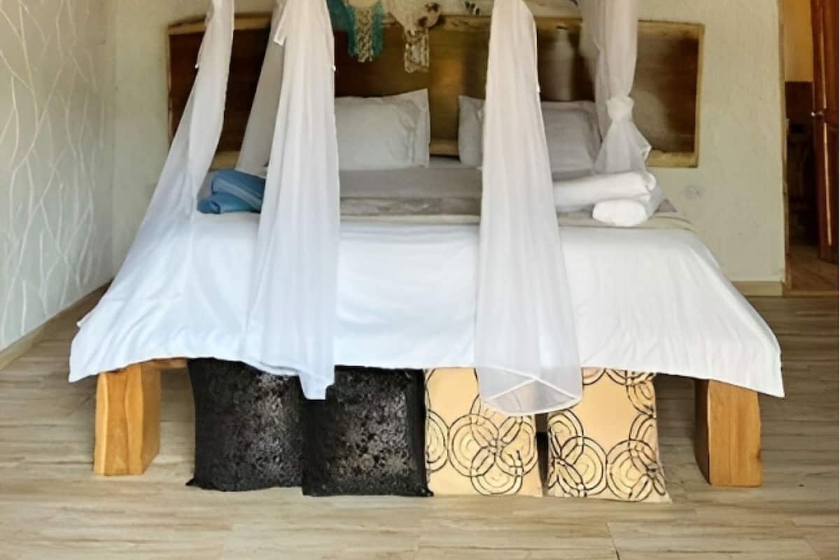 A room with a four-poster bed, a wooden ceiling, and a mural on the wall.