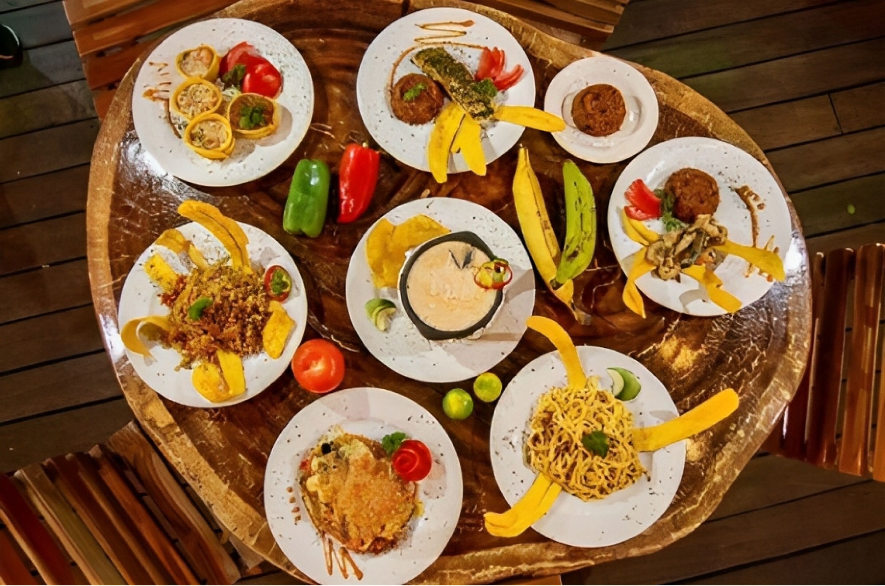 A wooden dining table with various dishes, including stuffed peppers, a bowl of sauce, and a plate of noodles.