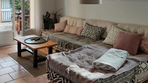 Una sala de estar acogedora con un sofá, una mesita de centro y una alfombra estampada.