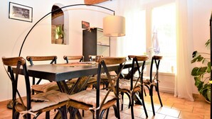 Un comedor con una mesa grande, seis sillas y una lámpara colgante.