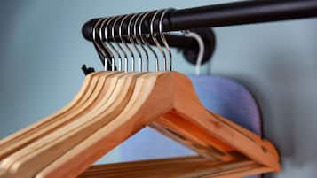 Un perchero de madera con un accesorio metálico.