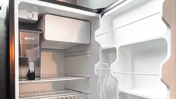 An open refrigerator with two shelves and a water dispenser.