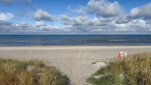 A beach with a clear path leading to the water, surrounded by grassy dunes. - Gorgeous home in Højby with WiFi (Højby)