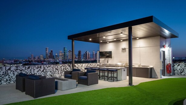 Un área de bar al aire libre con asientos y una vista del horizonte de la ciudad.