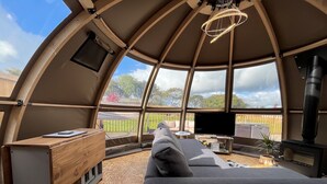 A cozy interior with a wooden desk, a comfortable sofa, a TV, and a fireplace. - Moonlight Tent (Tenby)