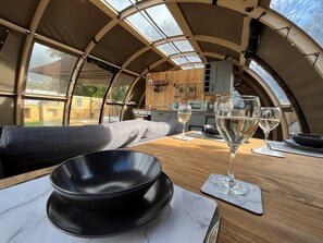 Un intérieur chaleureux avec une table en bois, deux verres de vin blanc et un bol noir.