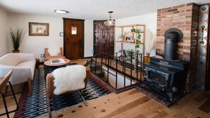 Un salon chaleureux avec une cheminée, un canapé, une table basse et un tapis.