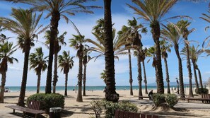 A beach with tall palm trees, a sandy shore, and a clear blue sky. - Beautiful 118-square-meter apartment in Salou. Families only (Salou)