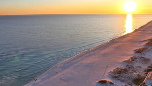 Una playa con vista despejada al océano y un atardecer.