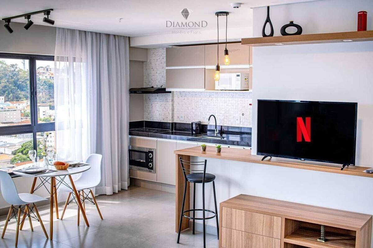 Une cuisine moderne équipée d’un four encastré, d’un four à micro-ondes et d’un grand téléviseur à écran plat affichant le logo de Netflix.
