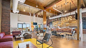 Eine geräumige Lobby mit Barbereich, Sitzgelegenheiten und einem gut sichtbaren Ausgangsschild.