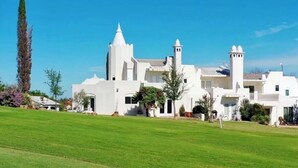 Un edificio grande y blanco con múltiples torres y un césped bien cuidado al frente.