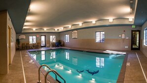 Una piscina interior amb marques de carrils ben definides, indicadors de sortida i un senyal d'advertiment de vigilant.