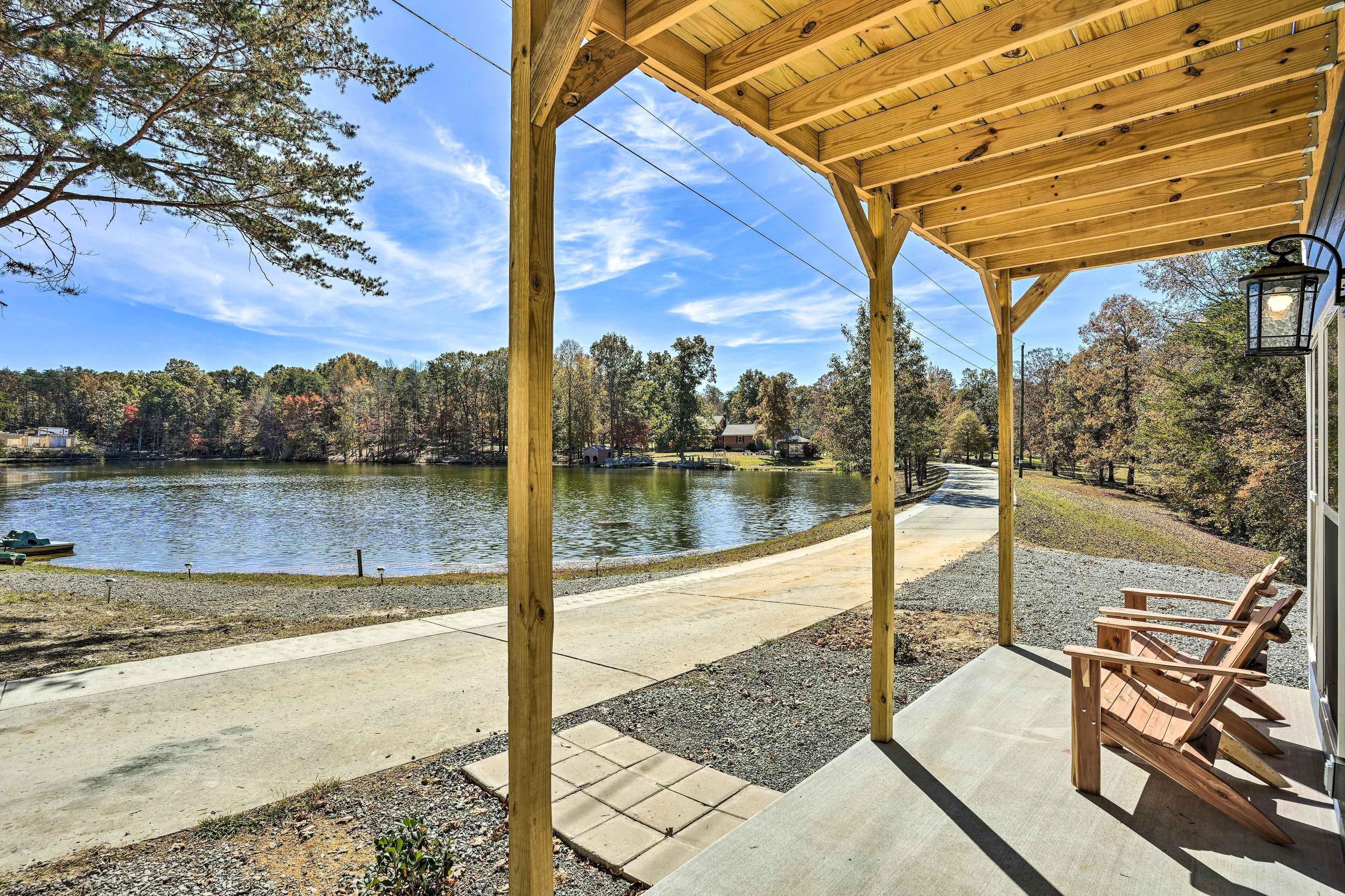 A wooden gazebo with a view of a lake and trees.