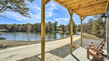 A wooden gazebo with a view of a lake and trees.