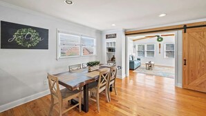A dining area with a wooden table and chairs, a bookshelf, and a sign that says "LAKE". - Lakefront Home w/Hot Tub, Fire Pit & Boat Slip (Eatonton)