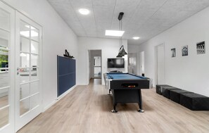 Relax and unwind in this modern space, featuring a pool table, flat-screen TV, and comfortable seating.