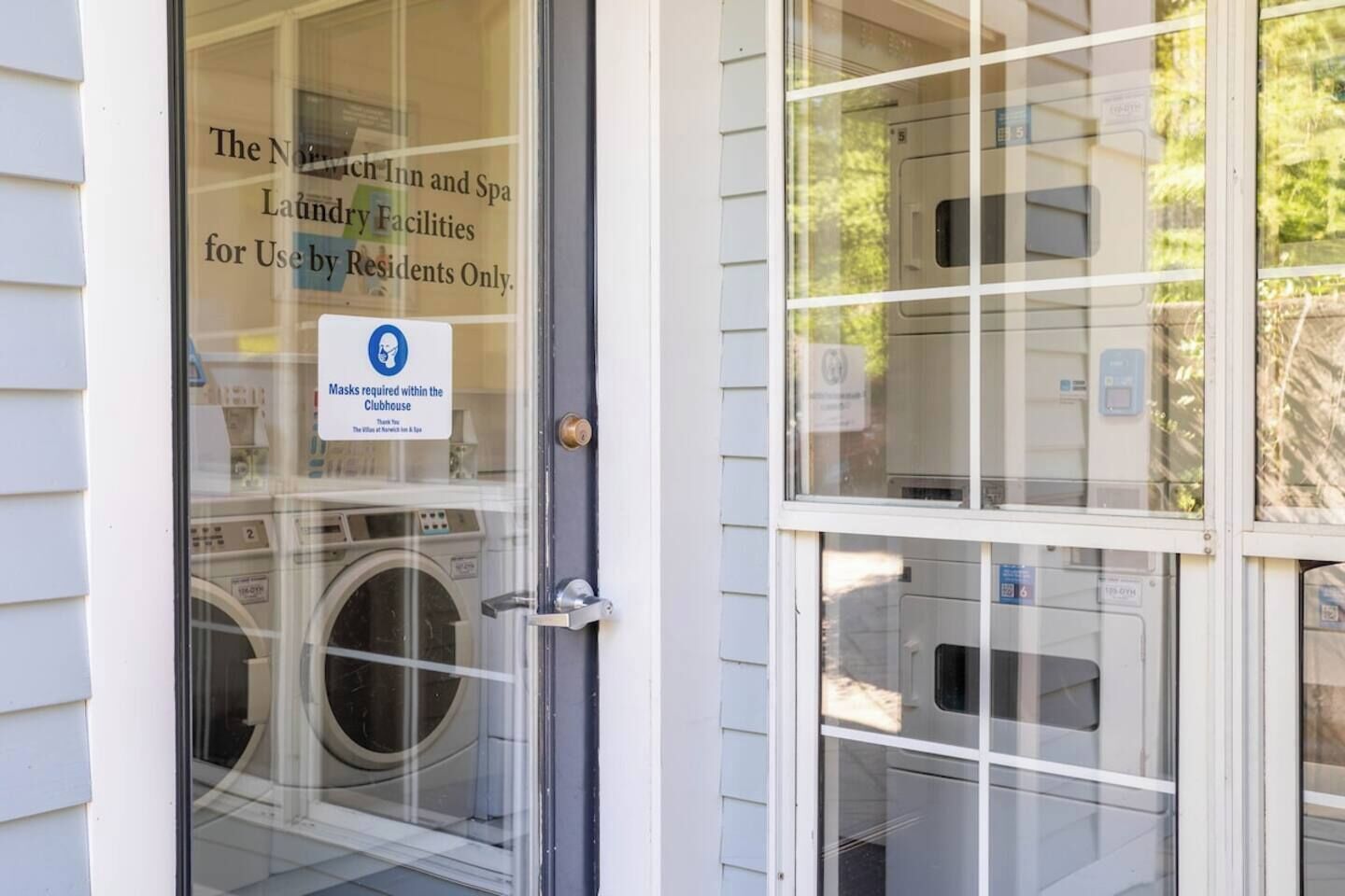 A hotel entrance with a sign indicating laundry facilities for residents only.