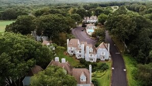 Vista aérea de una zona residencial con varias casas, una carretera sinuosa y una piscina.