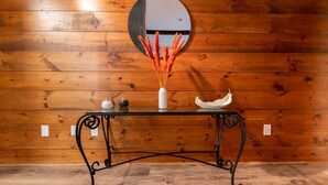 A wooden wall with a round mirror reflecting the ceiling. - Chimney Hill - 02) First-Floor Suite 2 (Lambertville)