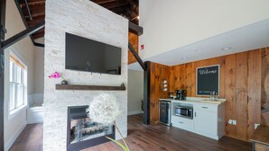 Una cocina moderna con chimenea de piedra, detalles de madera y un cartel de bienvenida.