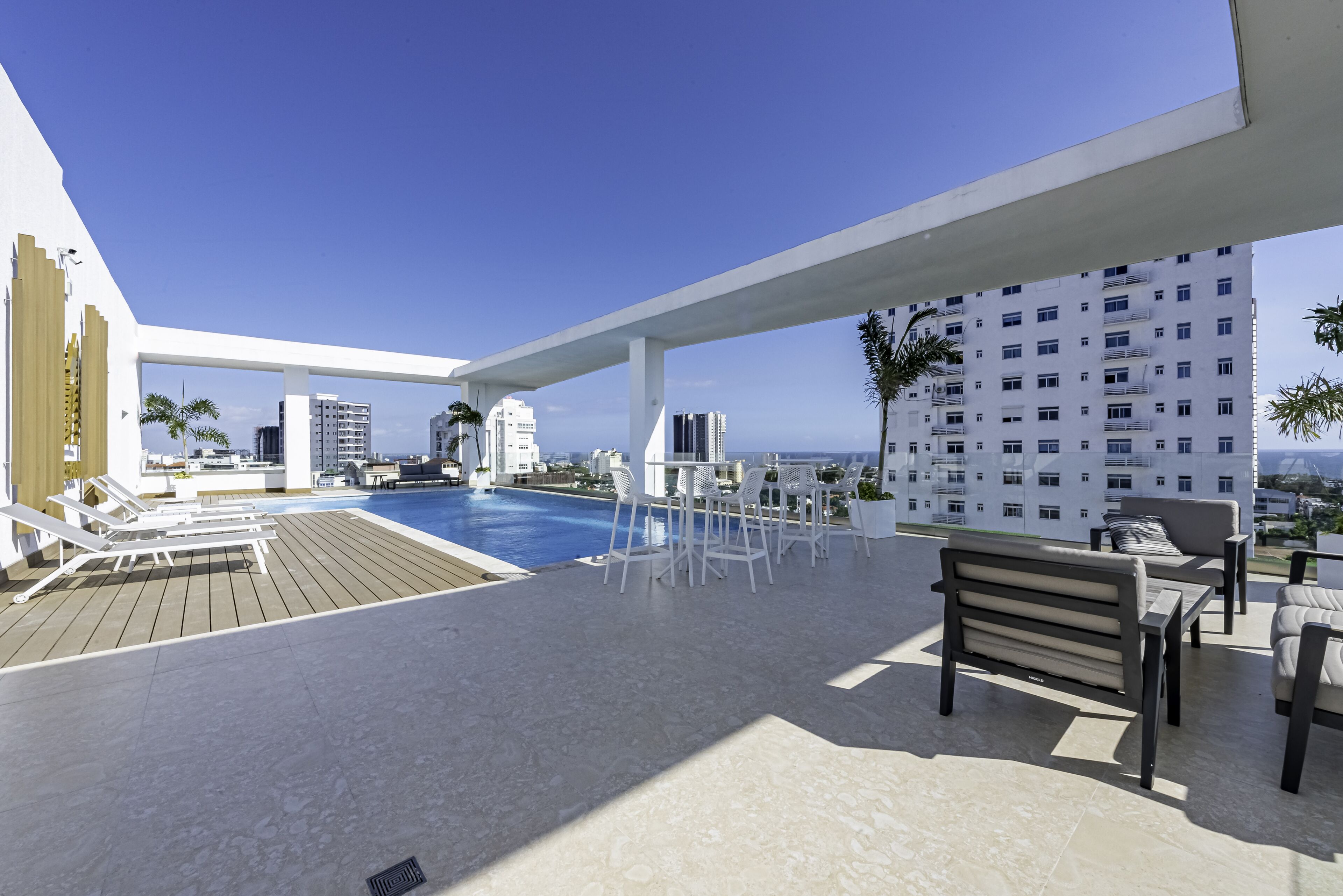 Una piscina al aire libre, sillones reclinables de piscina