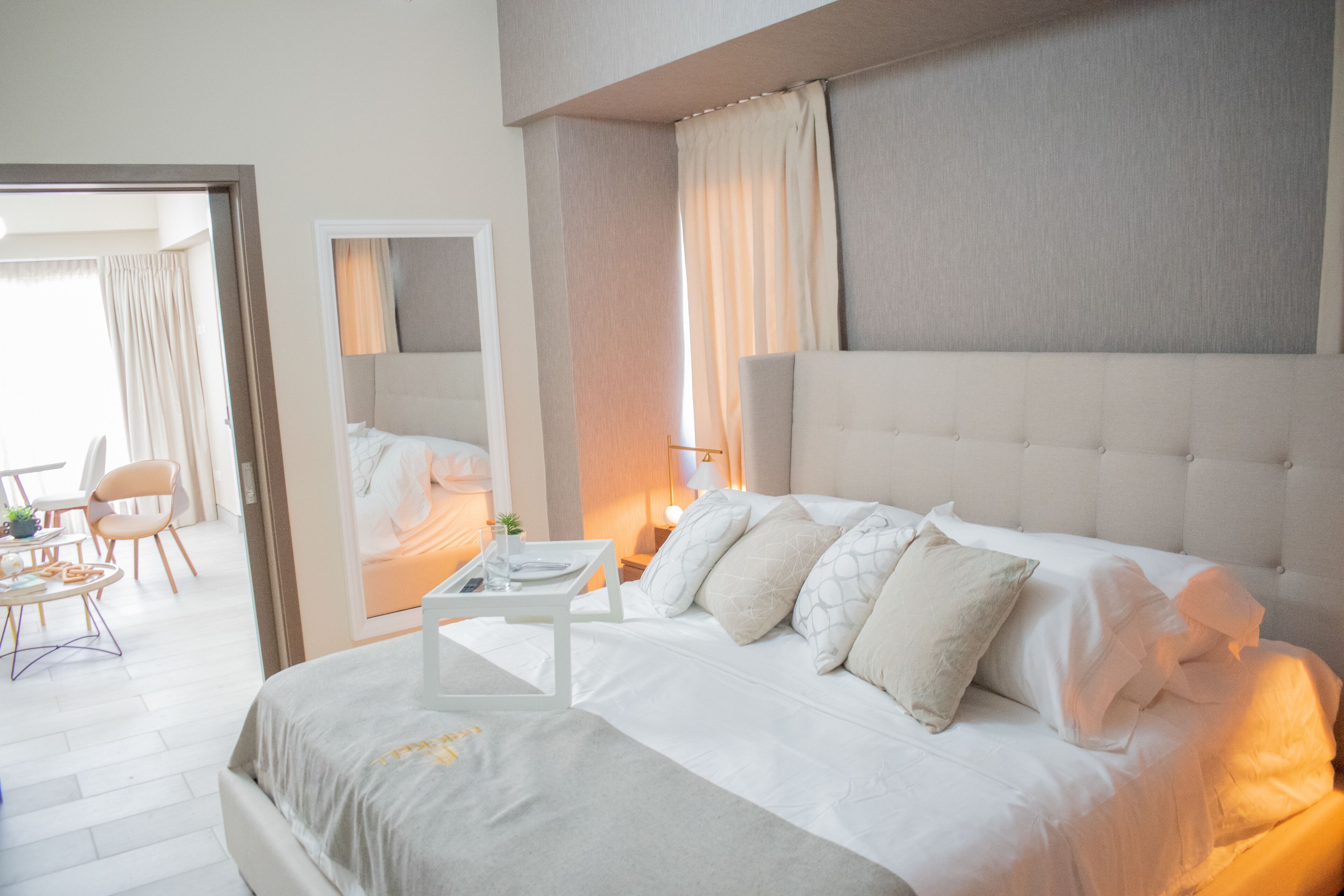 A modern hotel room with a large bed, a small table, and a chair.