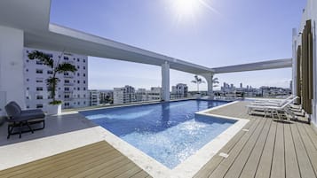 Una piscina al aire libre, sillones reclinables de piscina