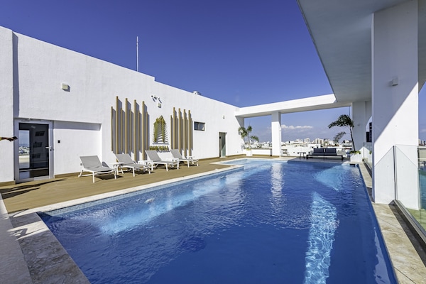 Een buitenzwembad en ligstoelen