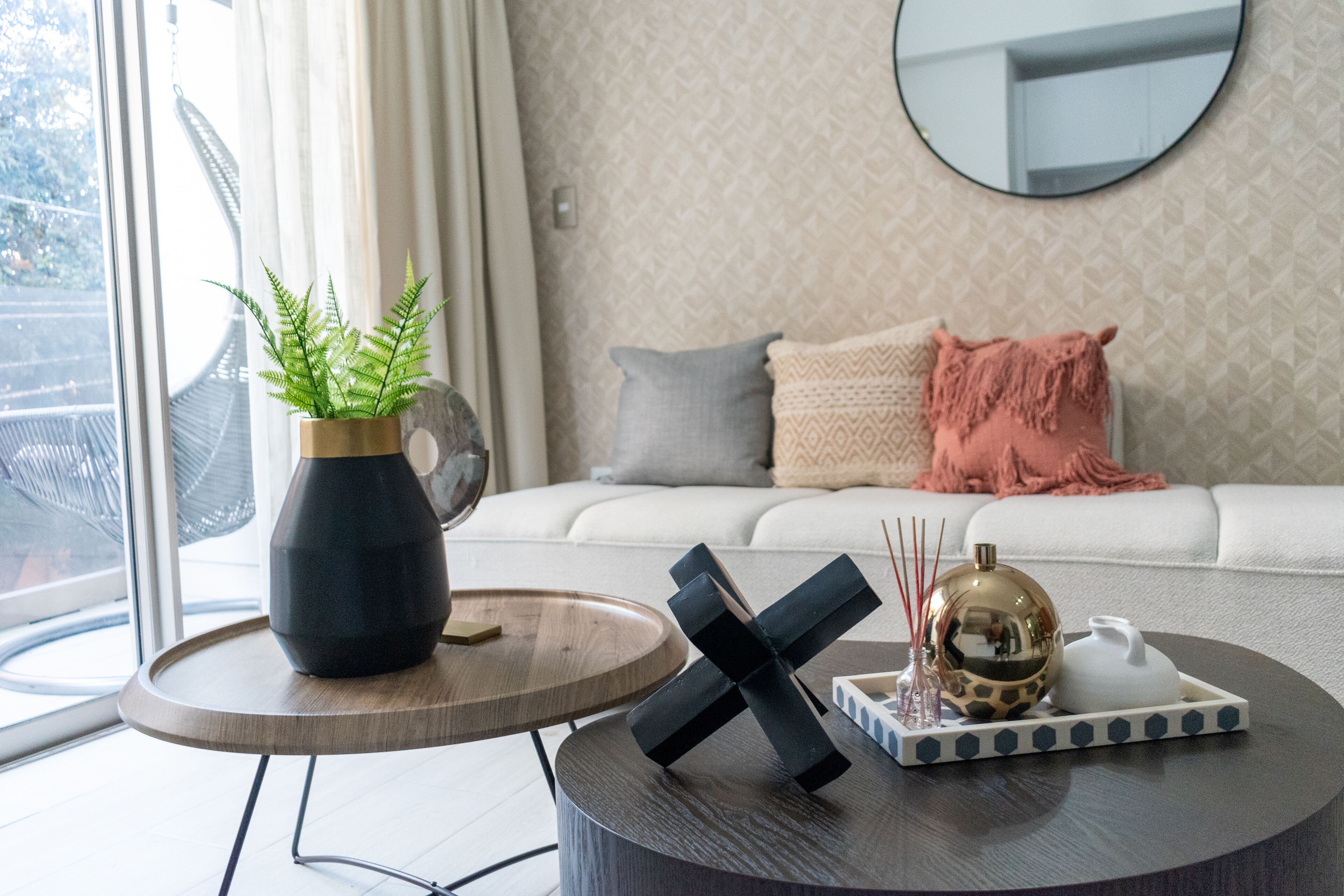 Un salon moderne avec une table basse ronde, une plante en pot et un bol décoratif.