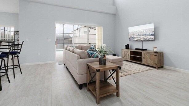 Ein geräumiges Wohnzimmer mit einer Couch, Couchtisch, Fernseher und Holzschrank.