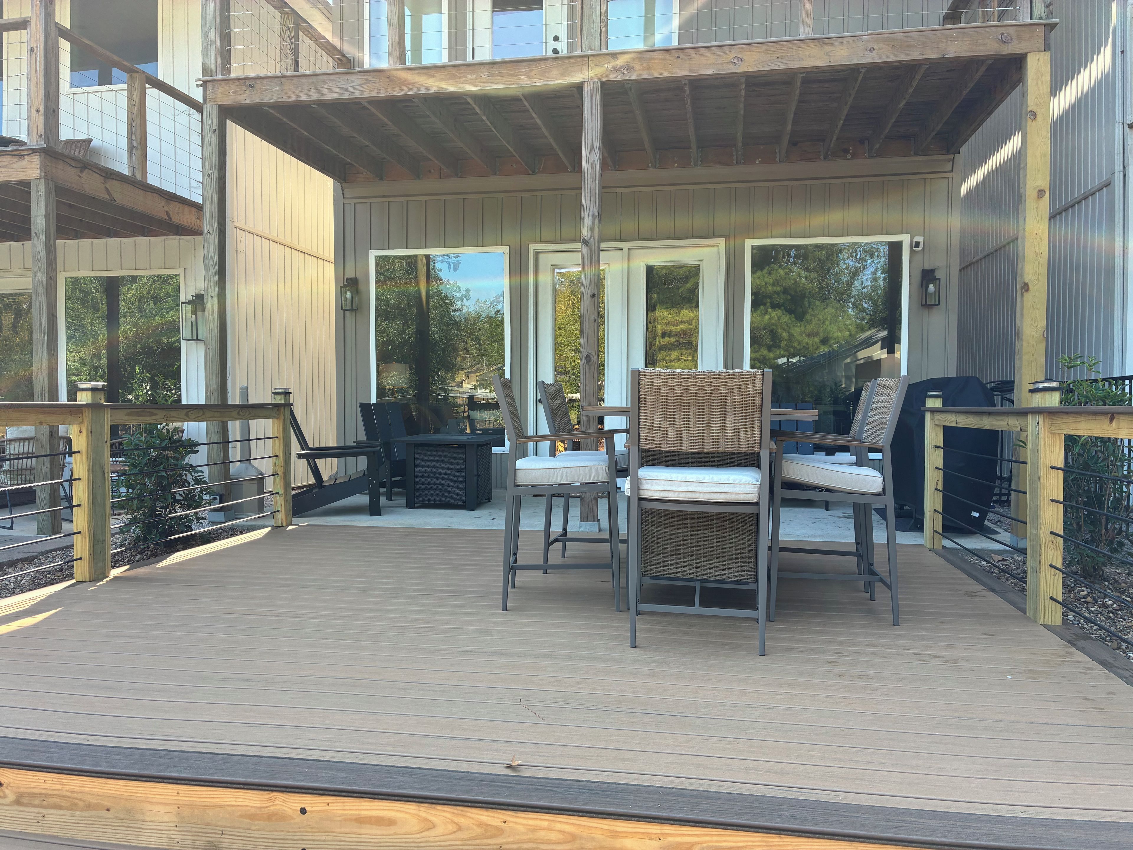 Une terrasse extérieure dotée d’un espace salon couvert, d’un barbecue et offrant une vue sur le paysage environnant.