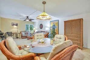 Relax in this stylish living room with a coffee table, wicker chairs, and a sofa.
