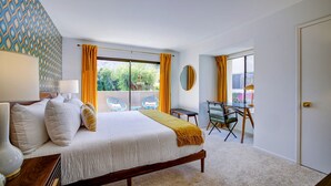 Habitación de hotel moderna con una cama grande, un escritorio y vistas al exterior.