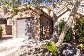 A residential house with a stone facade, a garage, and a landscaped driveway. - Canyon Cove at Coral Ridge 4239, Golf Course, and Sand Hollow Reservoir (Washington)