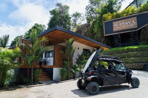 En moderne bygning med en træterrasse og et skilt, der står 'SEATAYA Ocean & jungle view villas'.