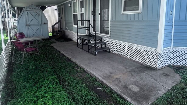 A house with a porch, a small table with chairs, and a shed. - Quaint and Quiet Tiny Home, with Pool Access! (Harlingen)