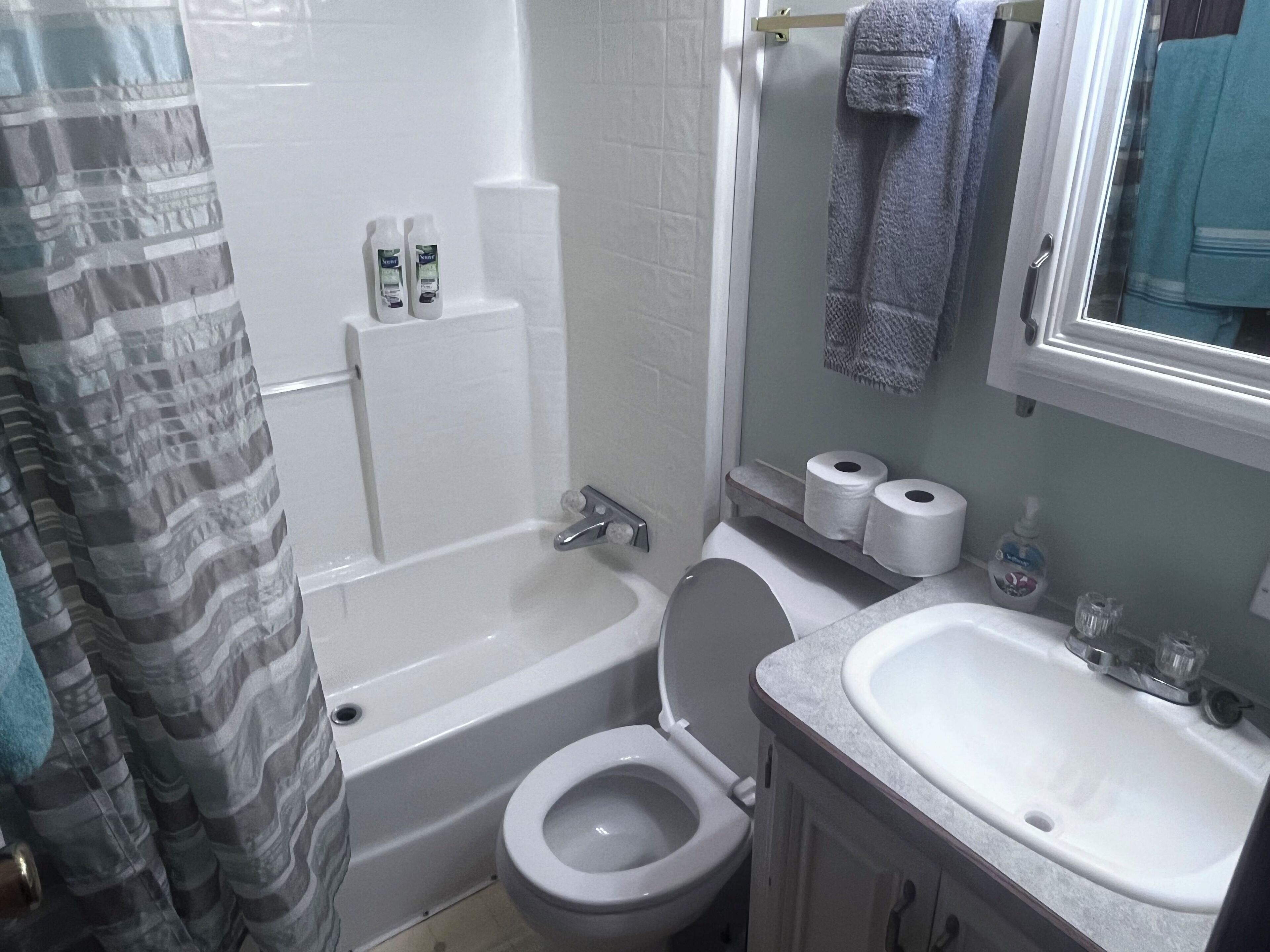 A bathroom with a bathtub, toilet, and sink.