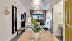 Ett modernt hotellrum med en lång hall, en matplats och ett vardagsrum.