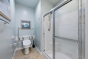 A bathroom with a toilet, sink, and a glass-enclosed shower.