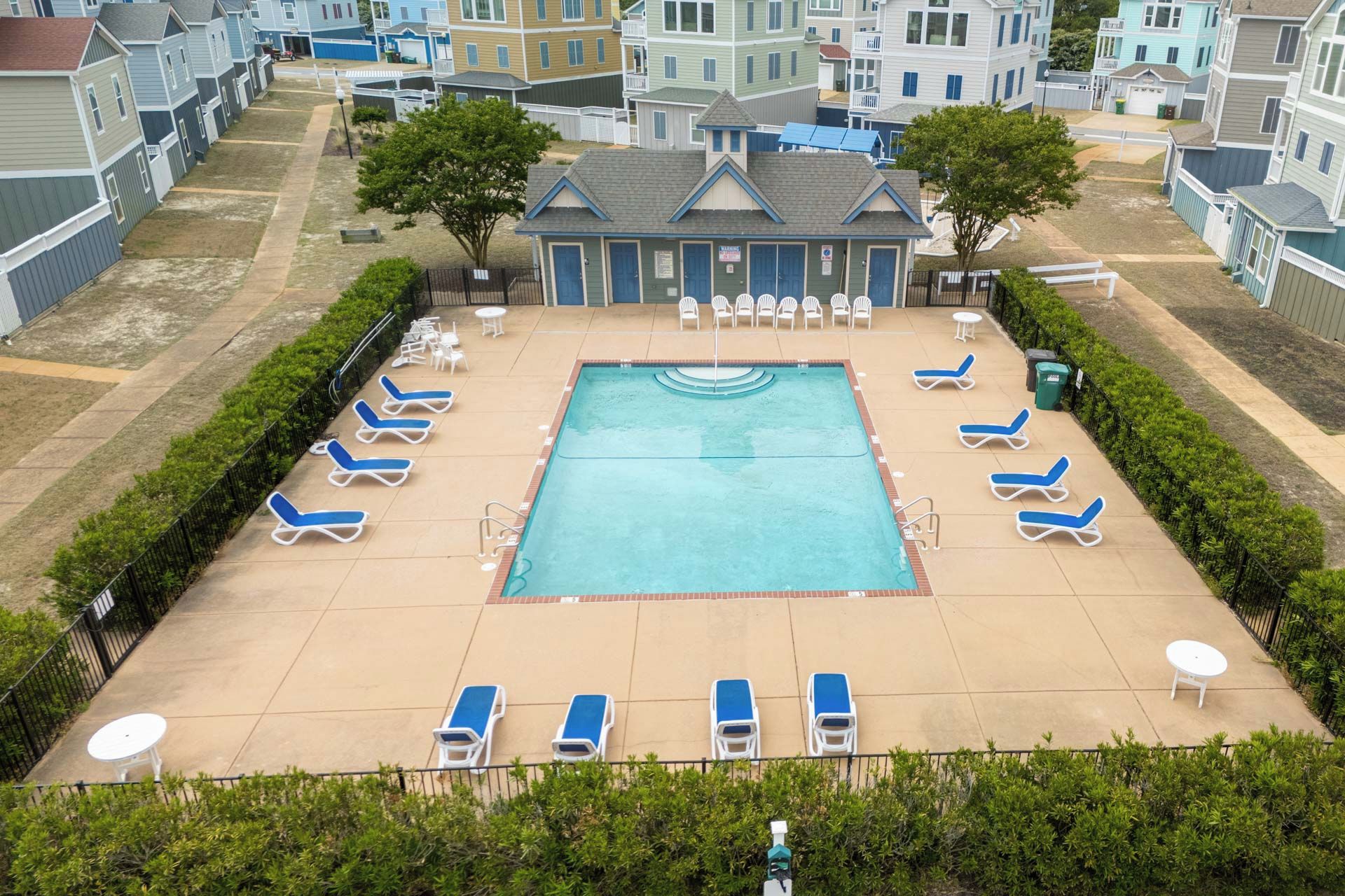 A swimming pool with lounge chairs and a small building with a sign.