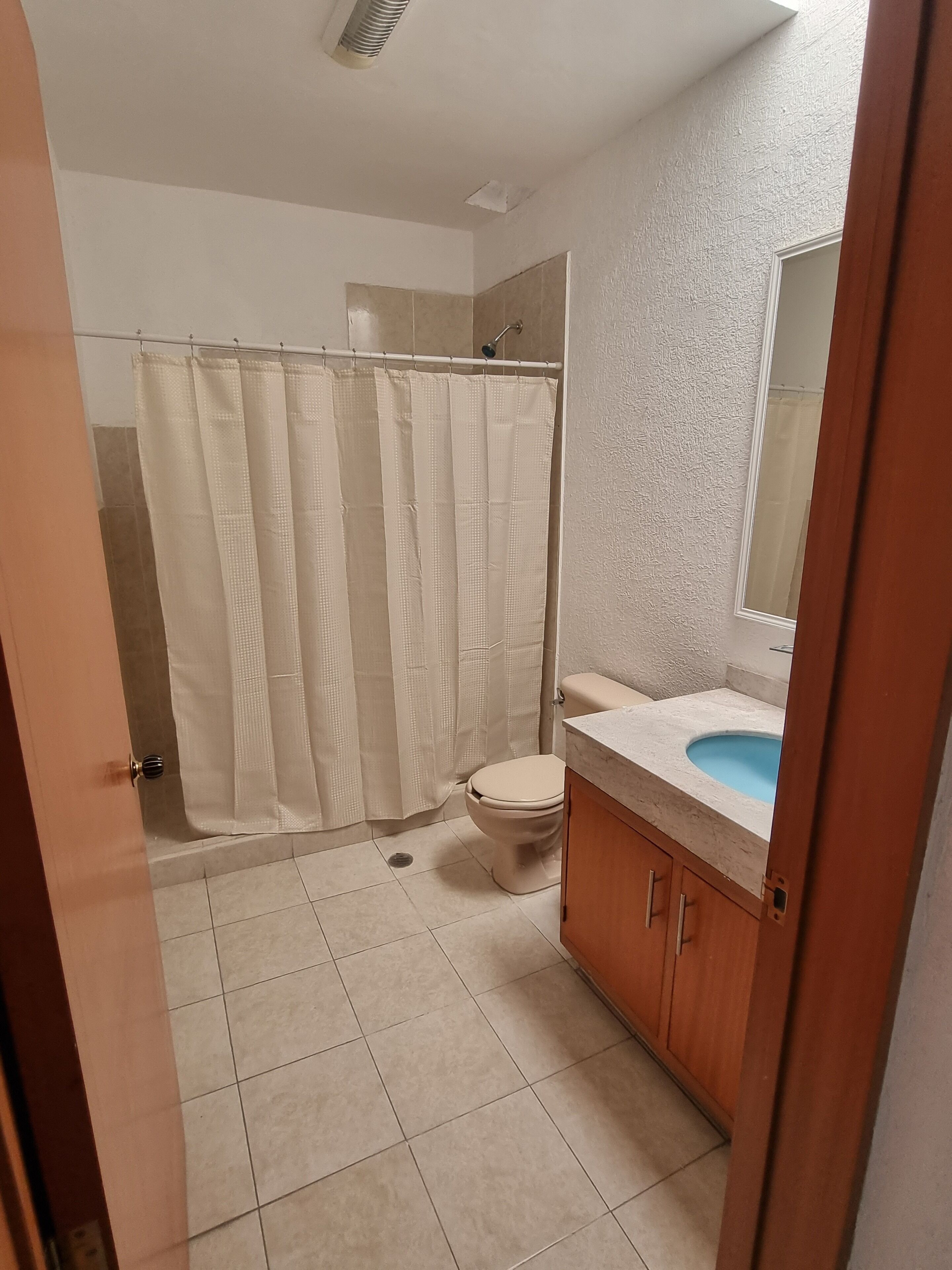 A bathroom with a shower, toilet, and sink.
