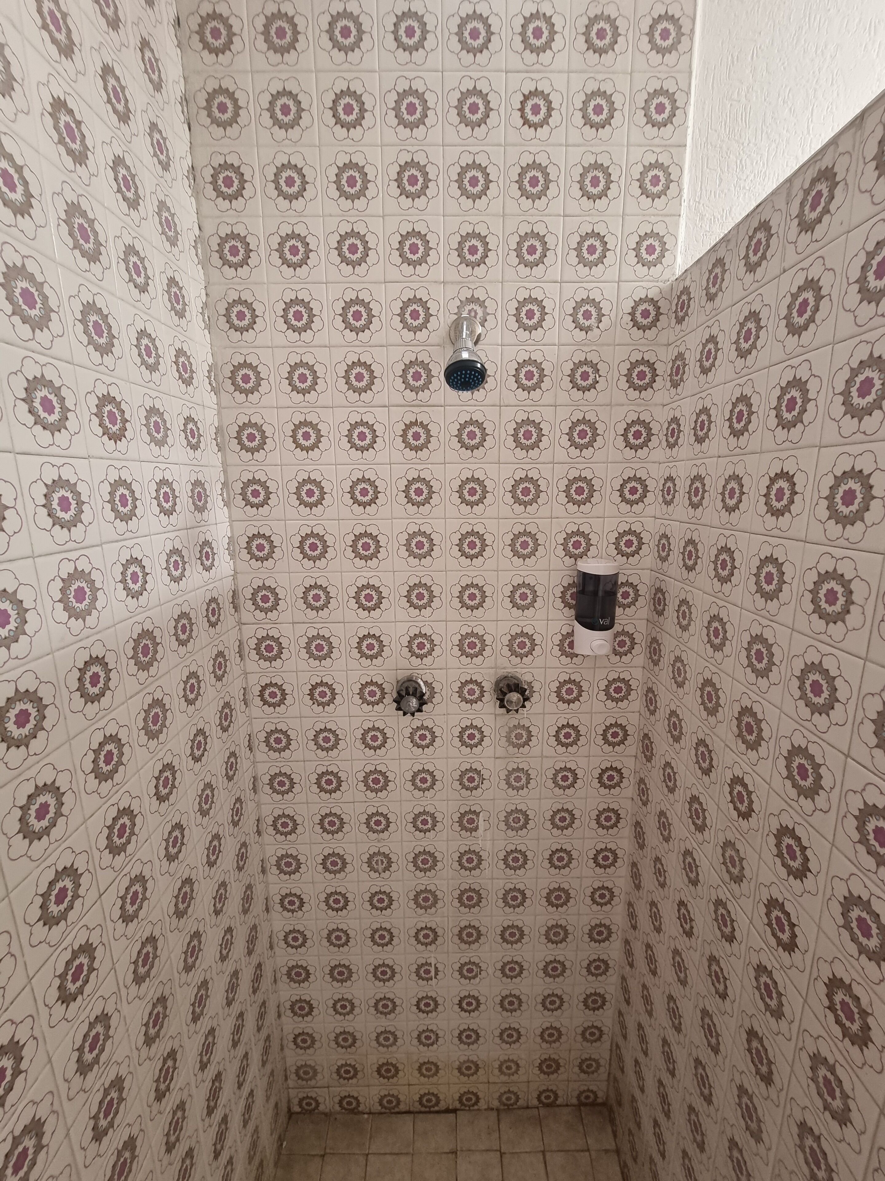 Un baño con baldosas estampadas y una zona de ducha.