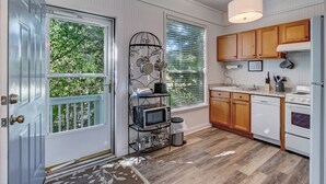 Une cuisine avec des meubles de rangement en bois, un four à micro-ondes et une cuisinière.