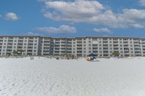 A beachfront hotel with multiple balconies, a sandy beach, and a clear sky. - Island Princess 404 * Beach Chair Set Included ~ Gulf Front! (Fort Walton Beach)