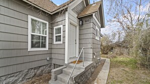 Une maison d’habitation avec un escalier en pierre menant à la porte d’entrée, une boîte aux lettres et le numéro « 523 » affiché sur la façade.