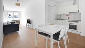 En modern lägenhet med matplats, kök och vardagsrum.